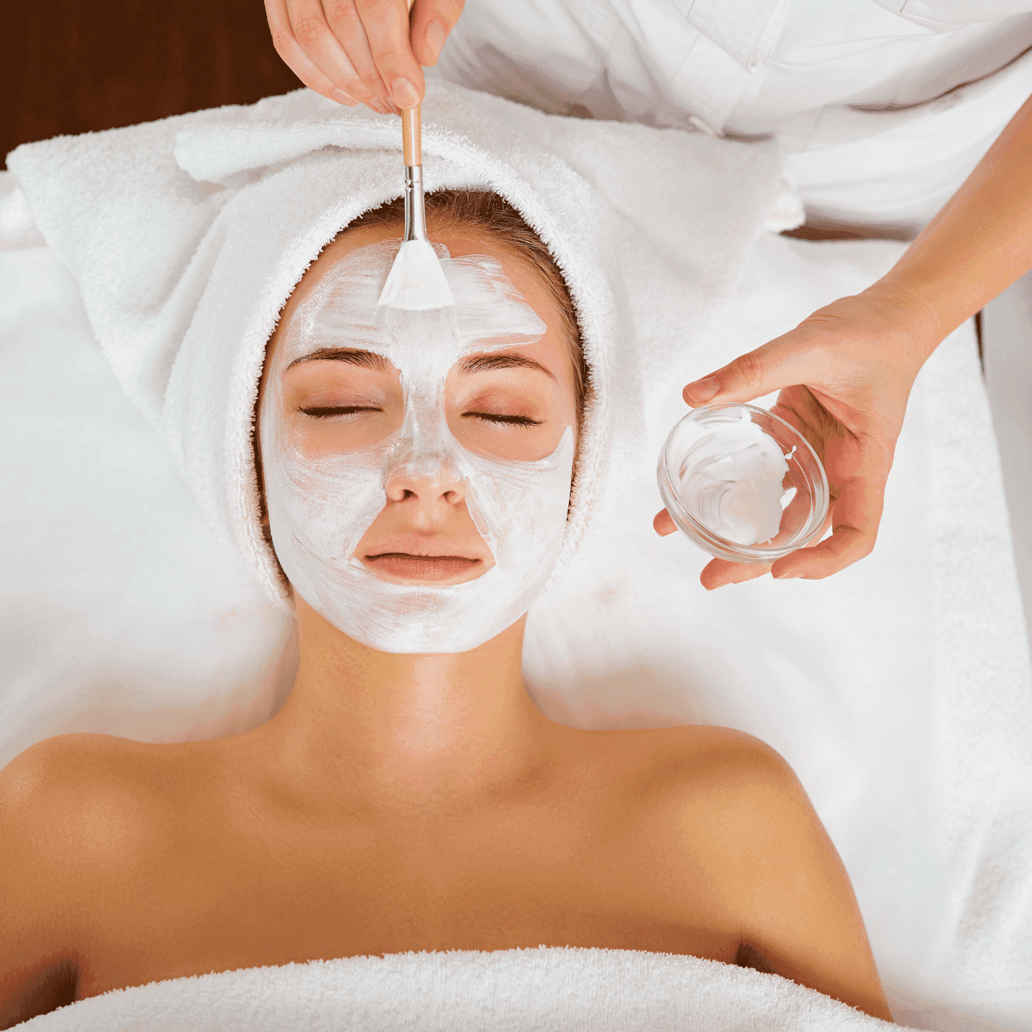 Facial treatment with cream applied to a relaxed person at a spa.