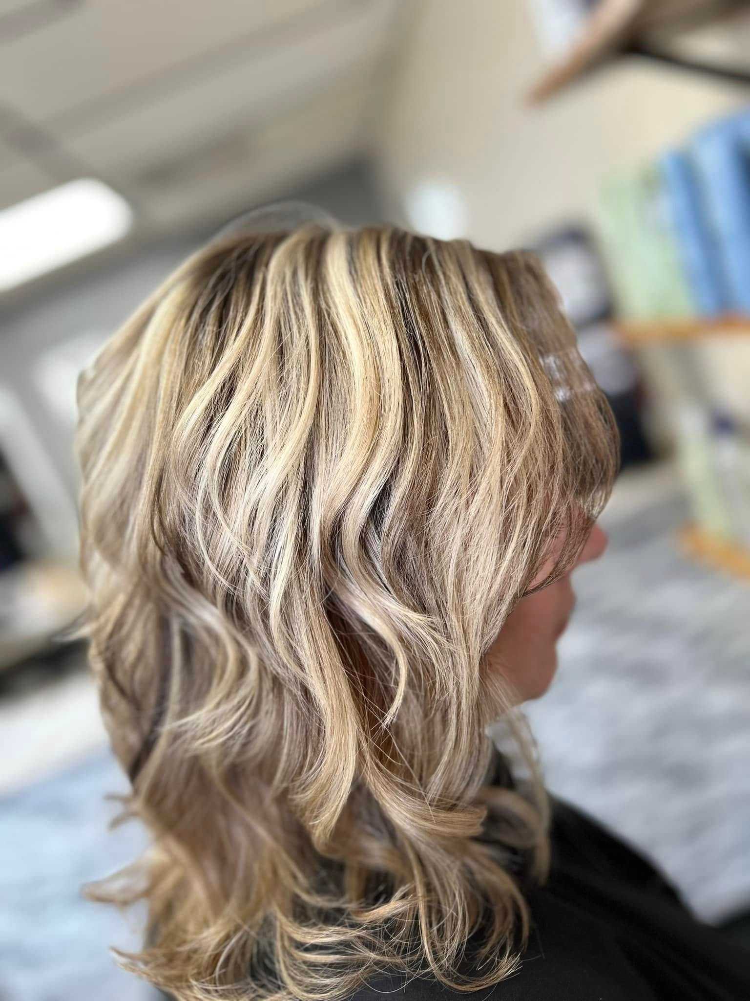 Woman's blonde hair with soft waves styled in a modern salon.